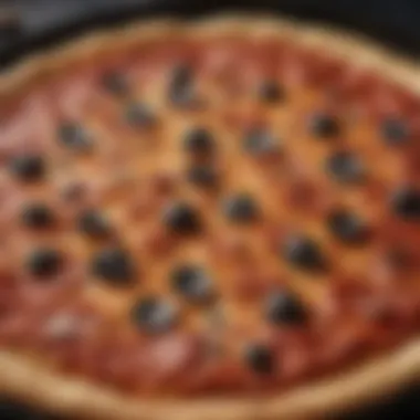 A close-up view of a black pizza pan with a freshly baked pizza, highlighting the crust's texture.